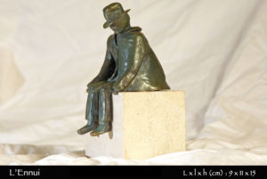 Personnage en bronze assis sur une pierre