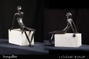 Personnage en bronze tranquillement assis sur une pierre