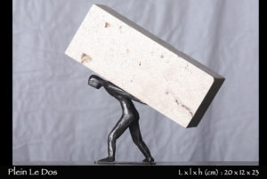 personnage en bronze portant une pierre sur son dos