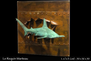 requin marteau en bronze longeant une épave de bateau